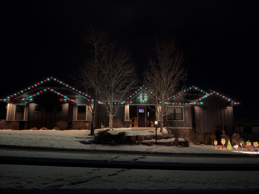 Home trimmed in alternating red and green C9 bulbs with snow across the front yard