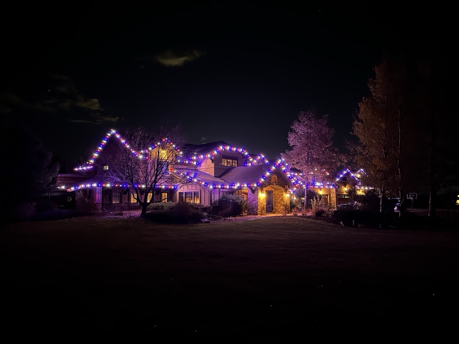Long estate elevation outlined in red, white and blue lights across every gable