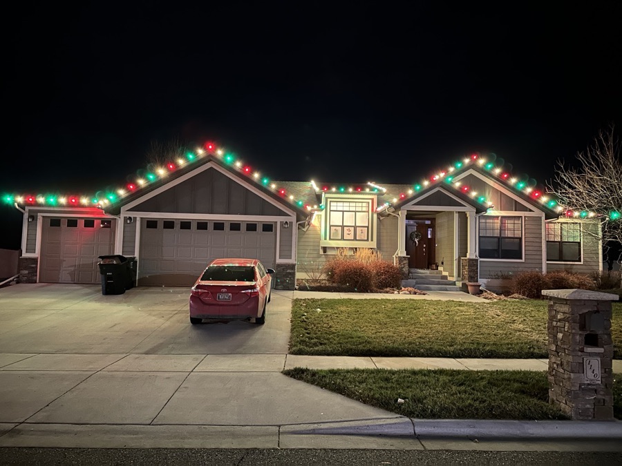Craftsman home trimmed in classic red and green roofline bulbs